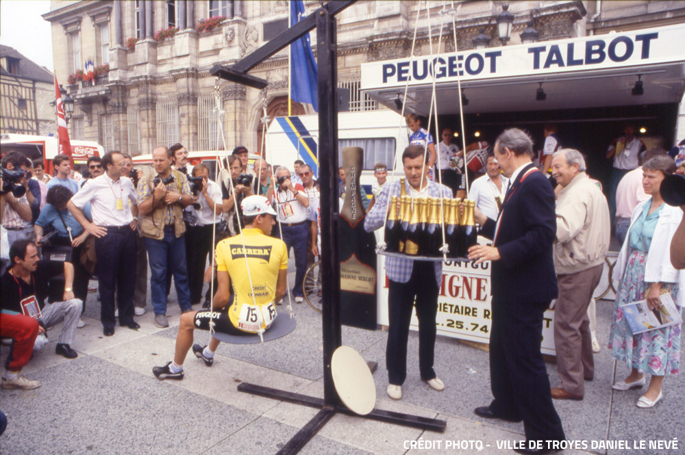 Le Suisse Eric Maechler de l’équipe Carrera se voit offrir son poids en champagne par le Maire de Troyes, Robert Galley